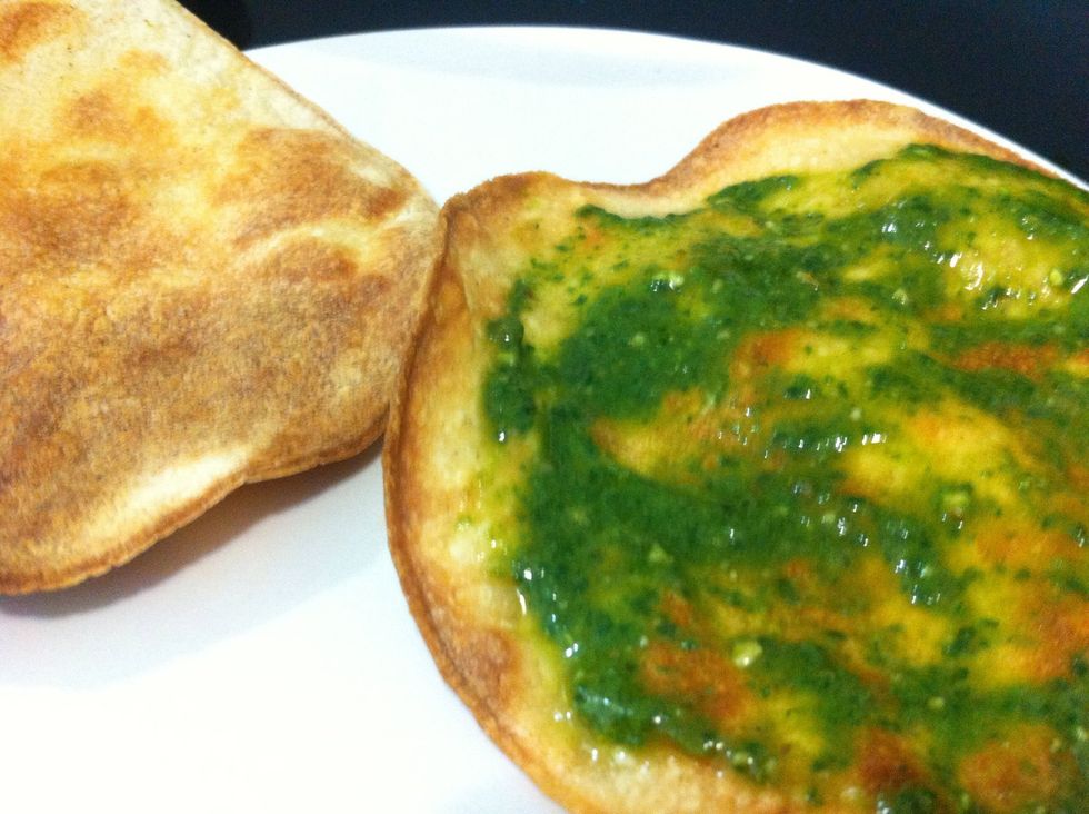 Spread pesto over tortilla