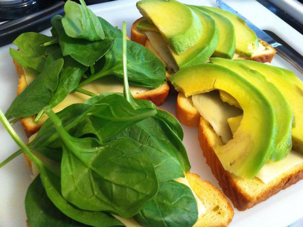 -Spread pesto sauce on both pieces of bread -Thinly slice avocados - 1 or 2 slices of cheese -Handful of spinach