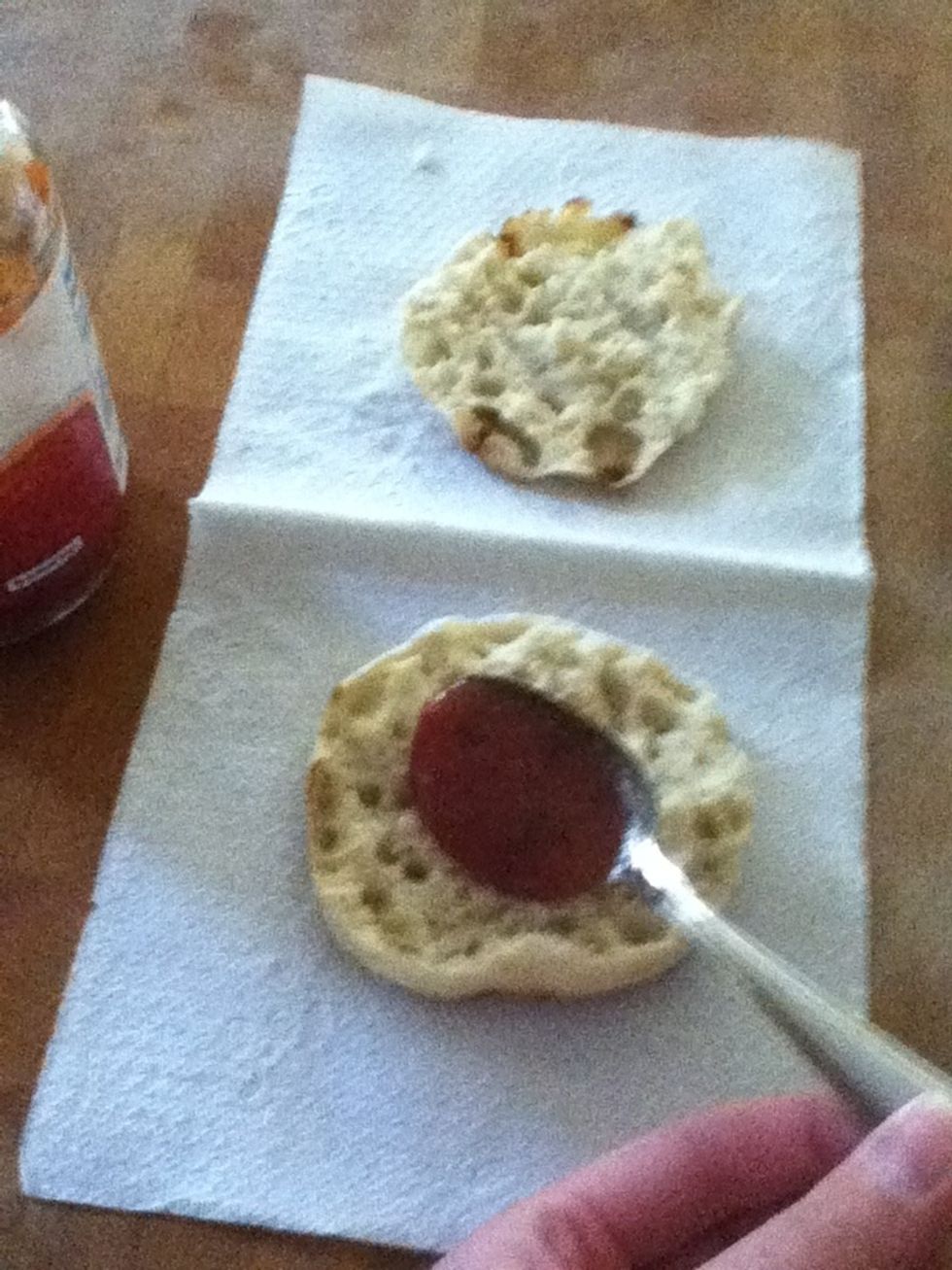 Spread pizza sauce on the English muffin.