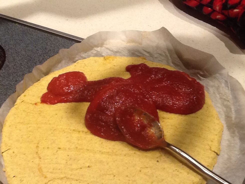 Spread pizza sauce, (part sauce part paste for us) on baked pizza dough. .