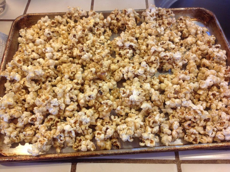 Spread popcorn on large jelly roll pans.  You will need a pan with an edge, for stirring up as it bakes.