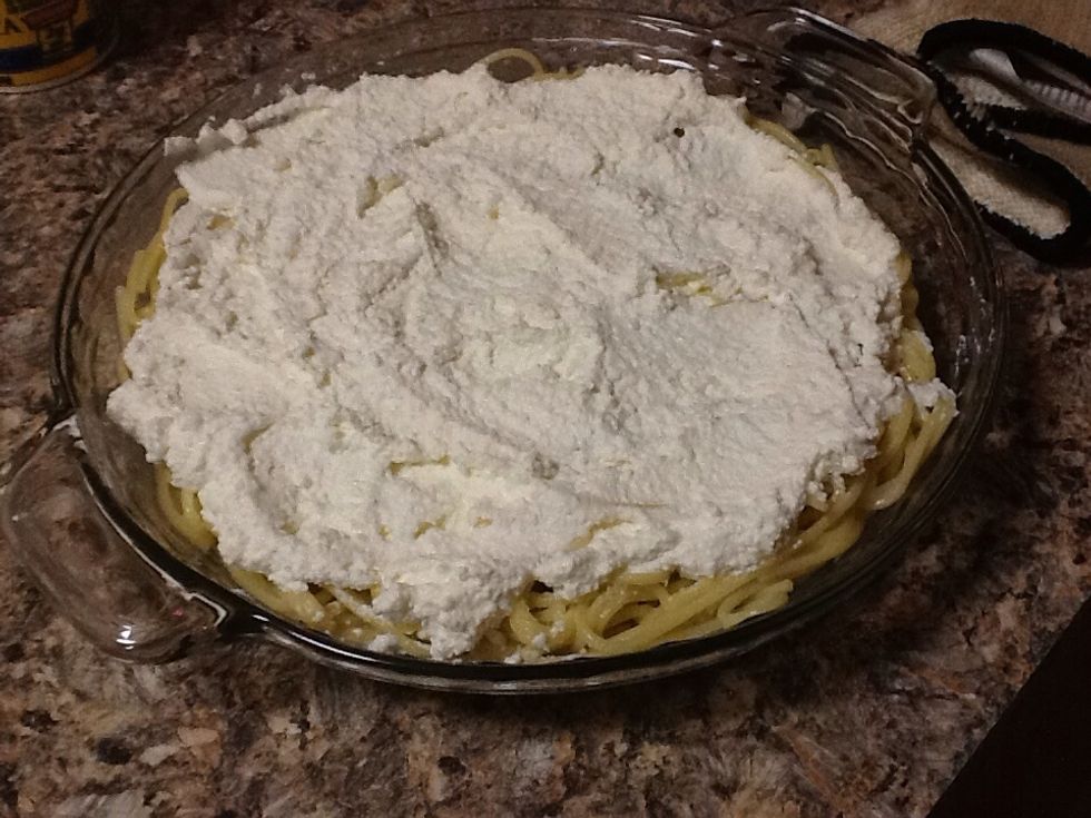 Spread ricotta cheese over the spaghetti crust.