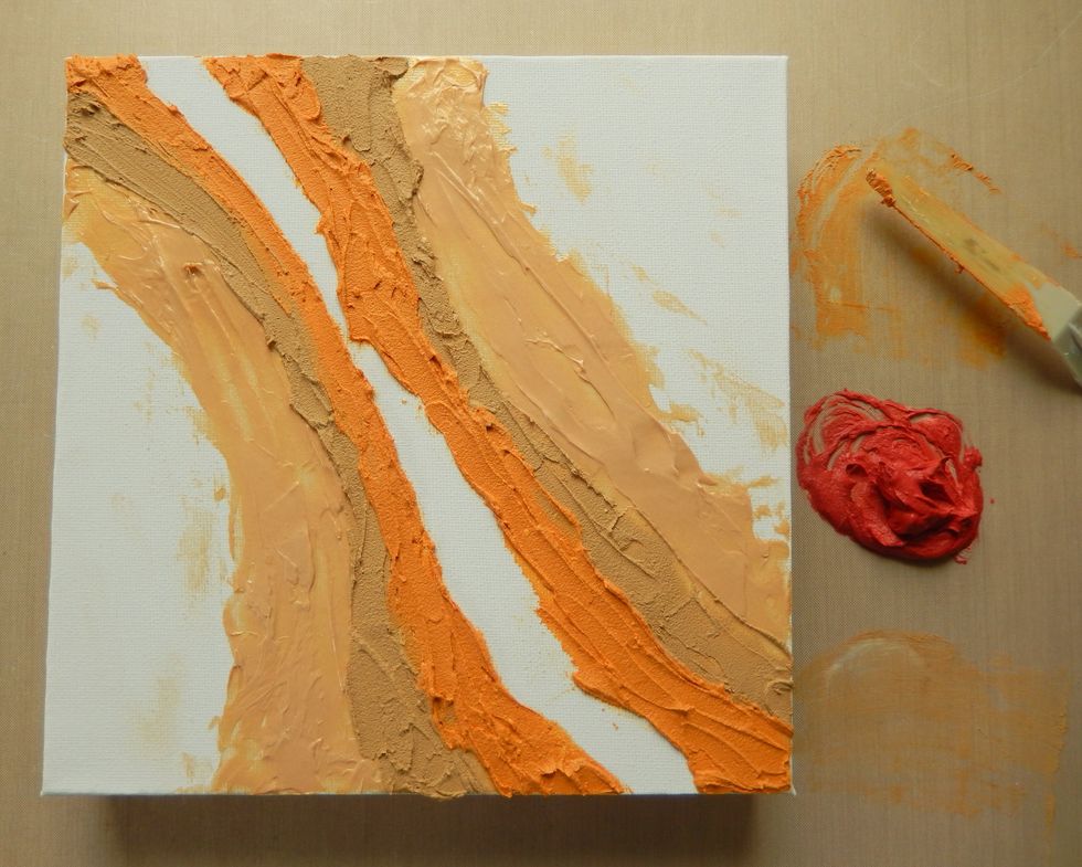 Spread the embossing paste mixed with the Orange Blossom Archival Reinker inside the existing paste lines.