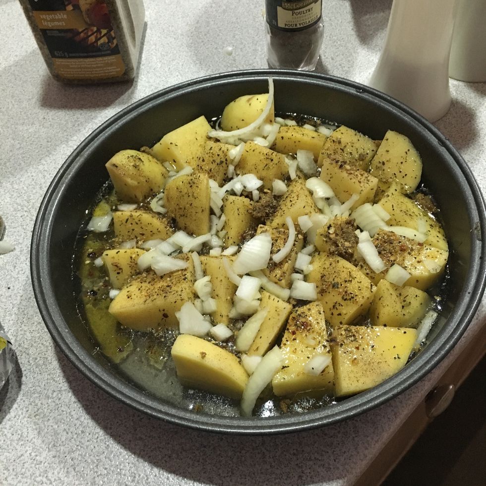 Spread the greek spice and onions evenly across the potatoes.