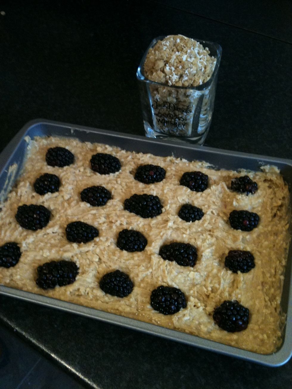 Spread the mixture out evenly in the baking tray. Push the brambles into the mix.