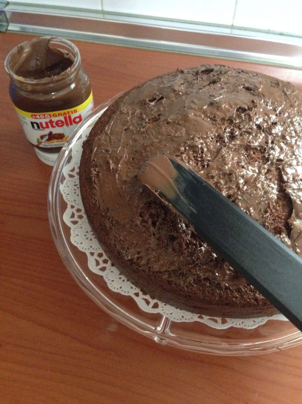 Spread the Nutella over the cake. ( Untar la Nutella por encima del bizcocho )