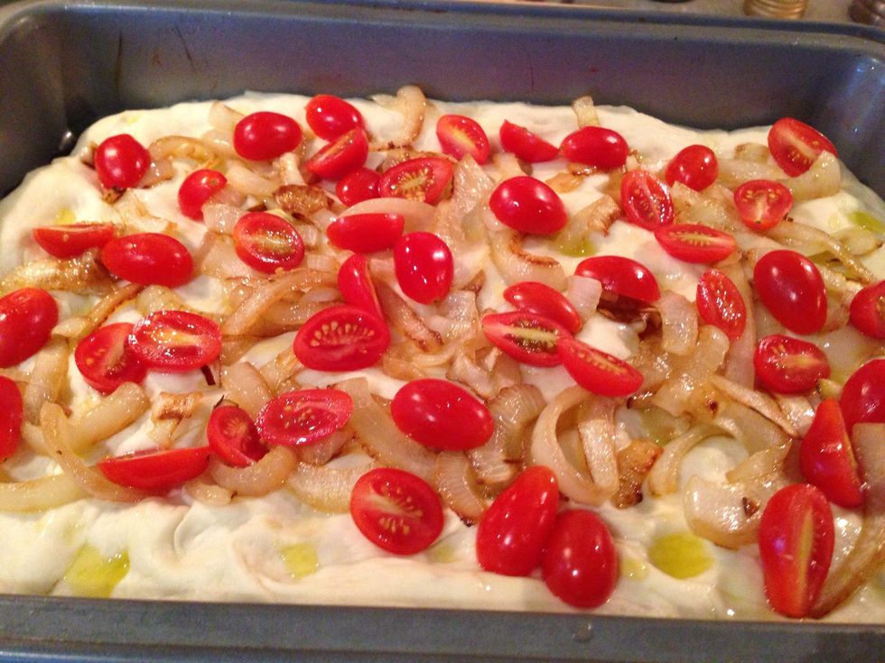 Spread the onions and tomatoes over the dough.