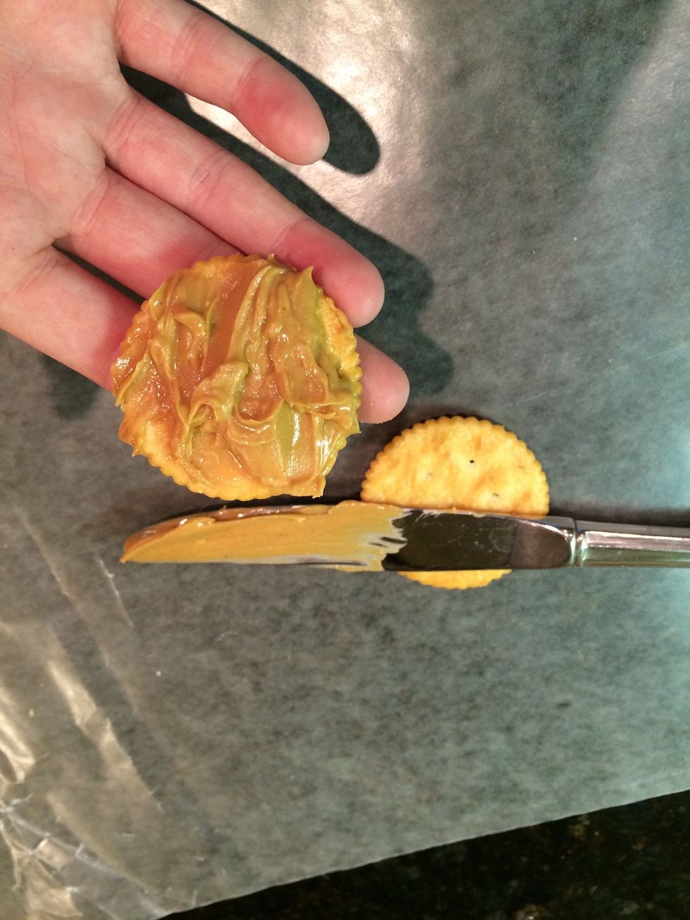 Spread the peanut butter on one cracker then take another cracker and put them together.