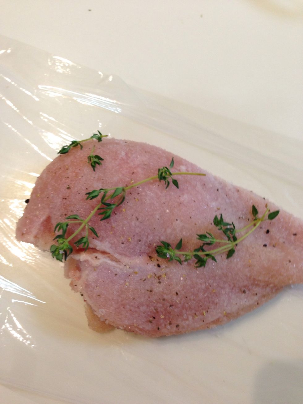 Spread the plastic wrap and place the chicken. Put a spring of thyme on it.