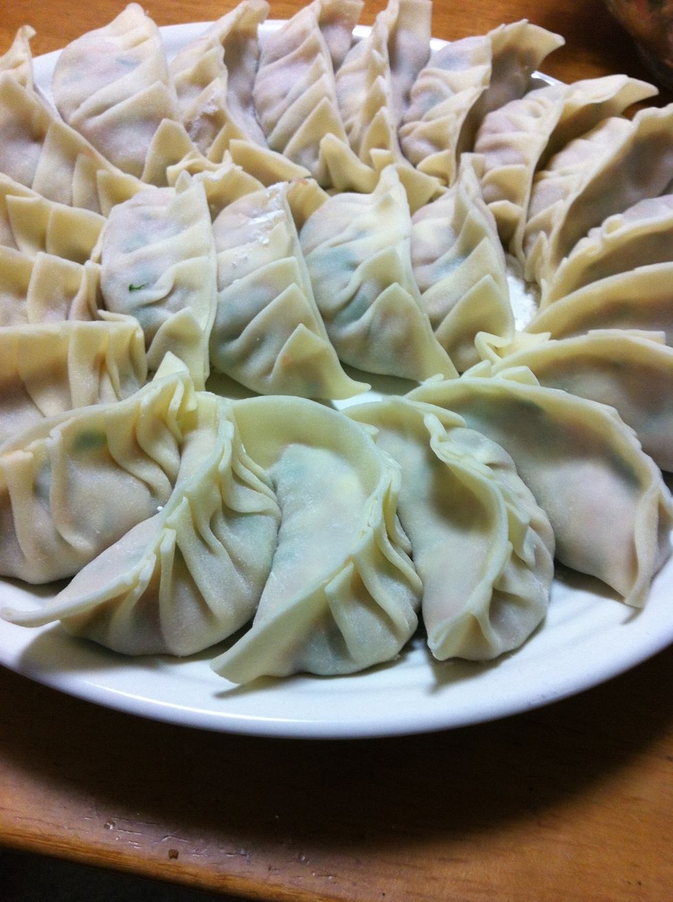 Spread the skin of gyoza on the palm, and put the fillings on it. Put the water on one side of the edge of skin, and paste both side. Make wrinkles like ripples on one side and wrap the gyoza.