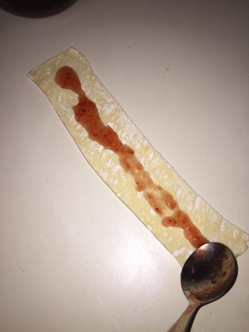 Spread the strawberry preserve and water mixture on a strip.