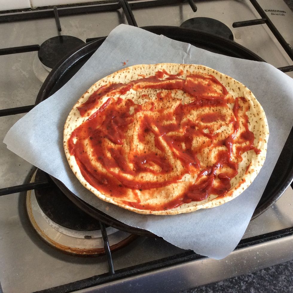 Spread the tomato paste over the pita bread