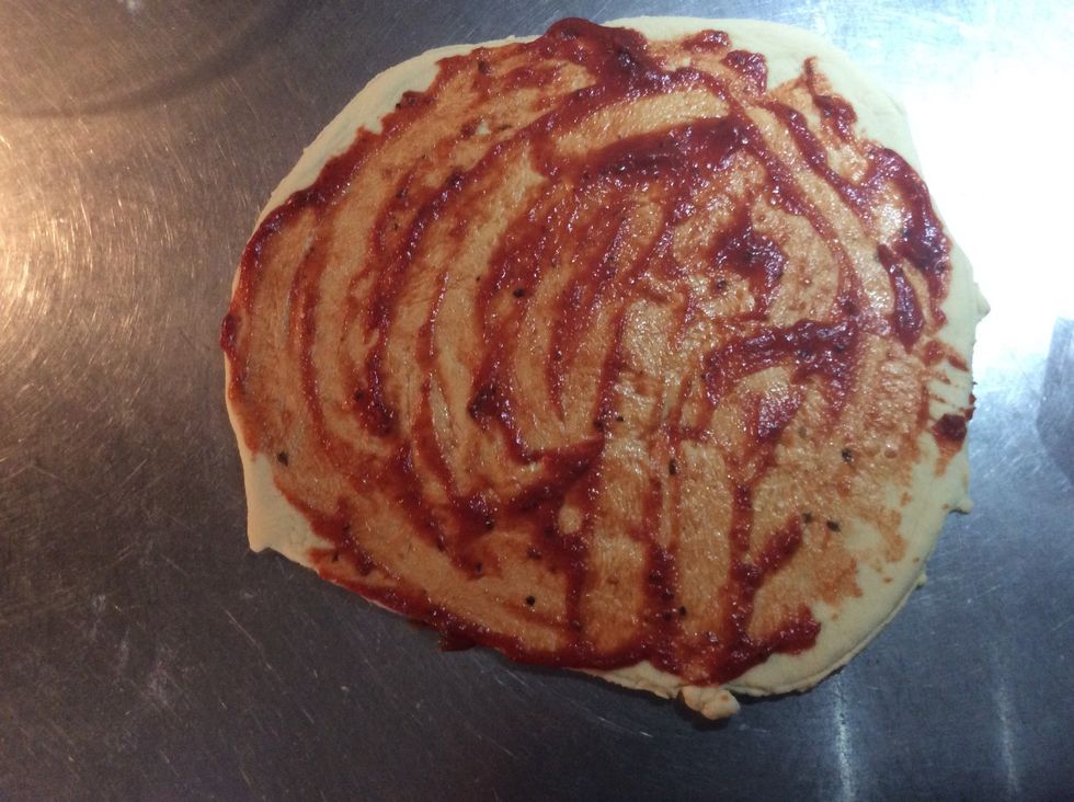 Spread tomato paste around pizza