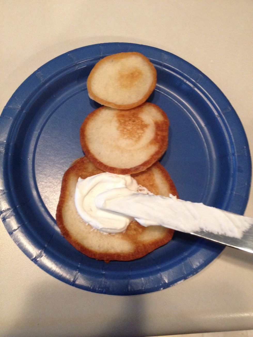 Spread whipped cream on each pancake, but leave the outline of the pancake showing.