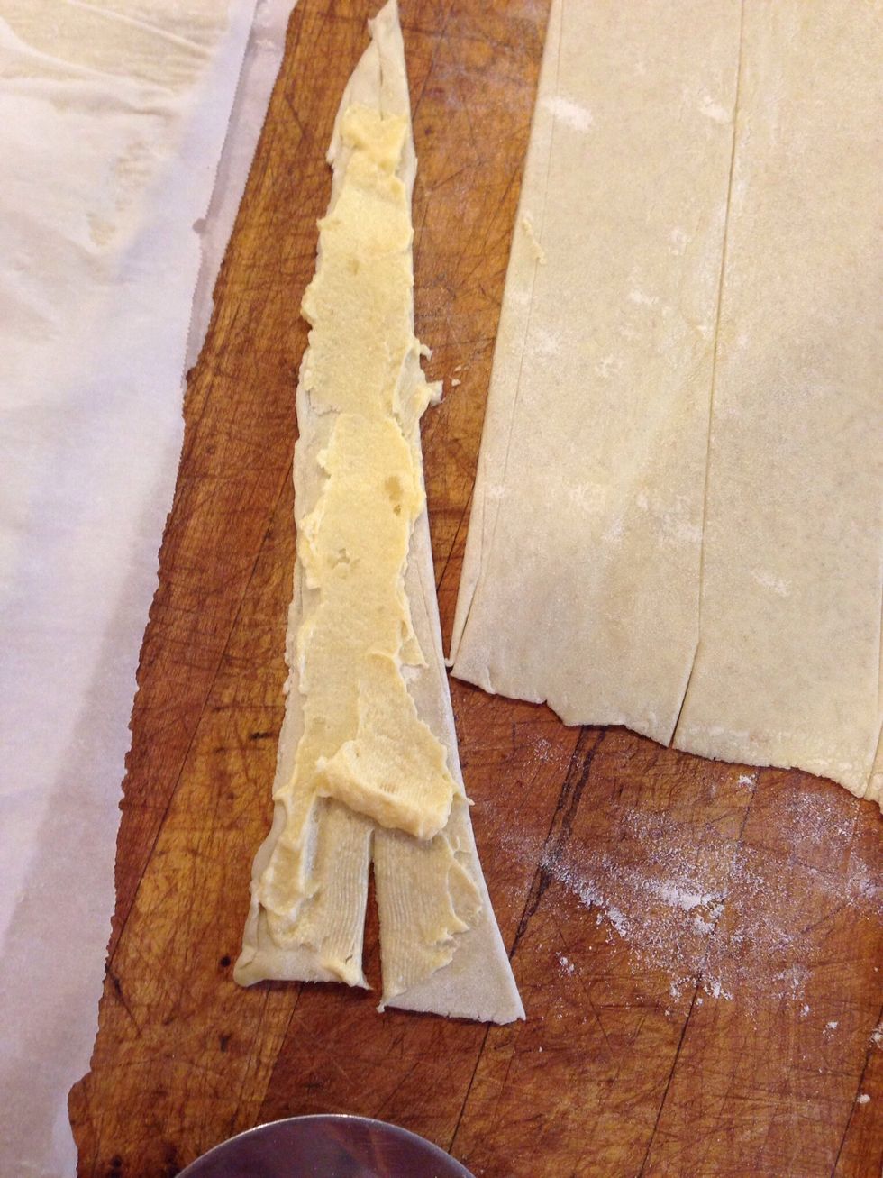 Spread with almond filling, and cut a notch I'm the wide end of the triangle of dough.
