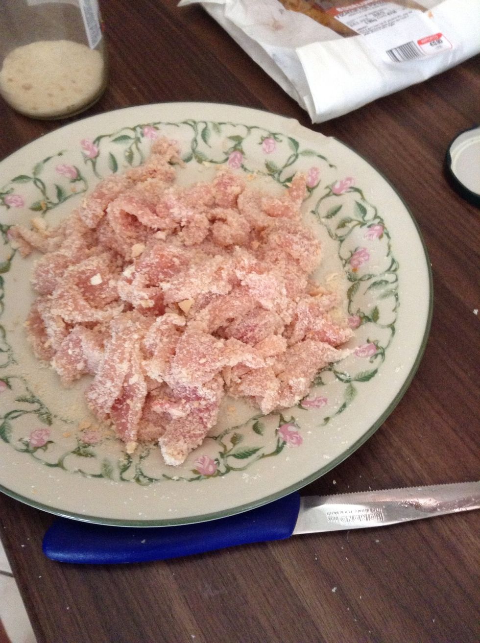 Spread your bread crumbs over the strips. Stick the crumbs on the breast mixing with your hands.