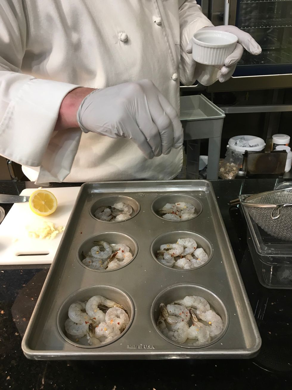 Sprinkle a pinch of black pepper over the shrimp in each section of the pan.
