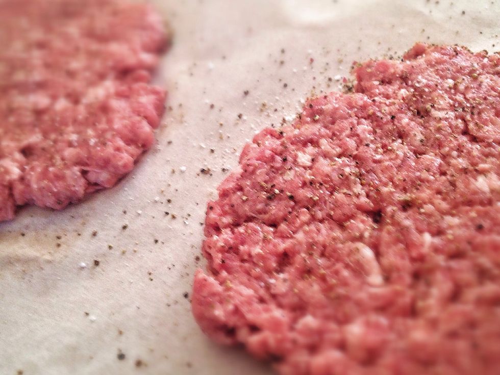 sprinkle a sheet of grease proof paper with sea salt and pepper, create balls with the beef and squeeze tightly to remove excess air, flatten on the paper and cover with pepper and salt