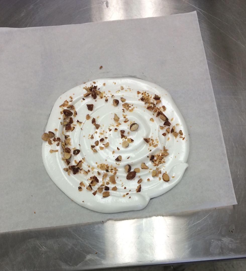 Sprinkle almonds onto each meringue layer.