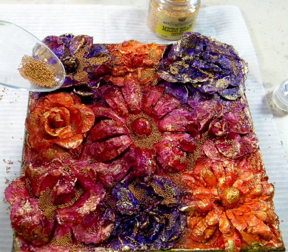 Sprinkle beads onto the canvas. Place paper under the canvas to catch those suckers! Turn the canvas over to remove the excess beads and return the extras to the container.