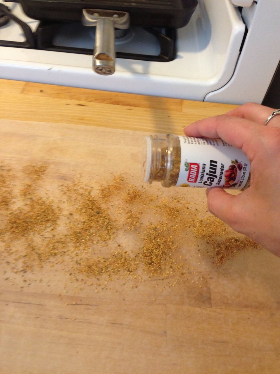 Sprinkle Cajun seasoning on a surface. I put down wax paper.