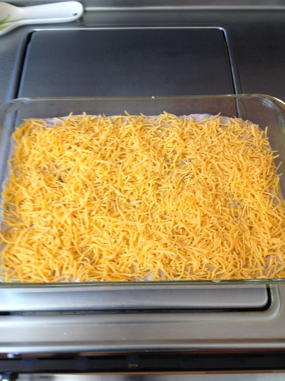Sprinkle cheddar cheese on top of mixture.