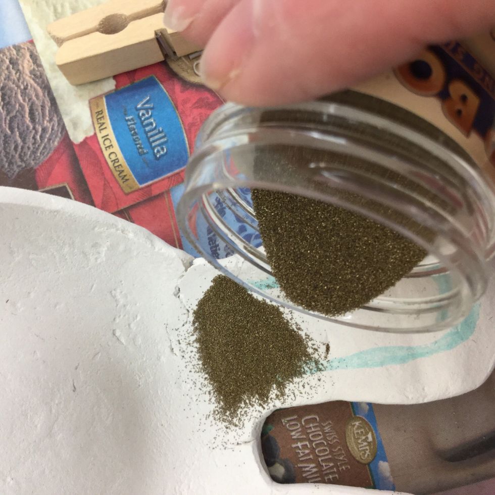 Sprinkle embossing powder over features you have drawn.