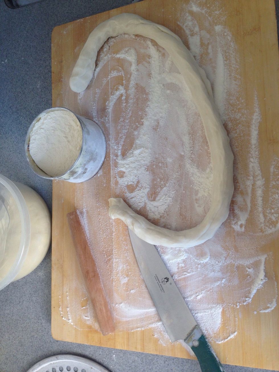 Sprinkle flour on table, oil hands, then knead a hunk of dough.