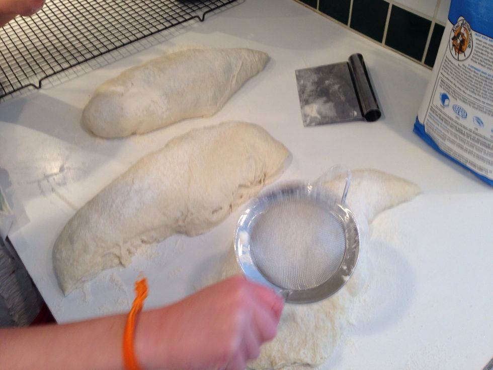 Sprinkle flour on the sticky spots of dough. We don't want it to stick to the counter when the slapping starts.