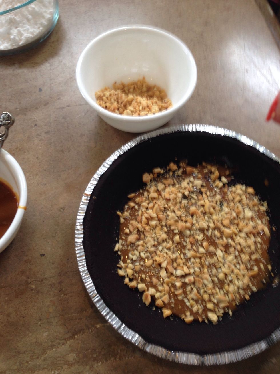Sprinkle half of the chopped peanuts over pie crust.