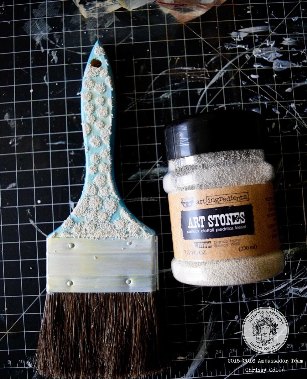 Sprinkle on Finnabair Mini Art Stones while playing Def Leppard\u2019s \u201cPour Some Sugar On Me\u201d. When it\u2019s almost dry, use a spray mist wand and drop ink onto the stenciled pattern to give the stones color