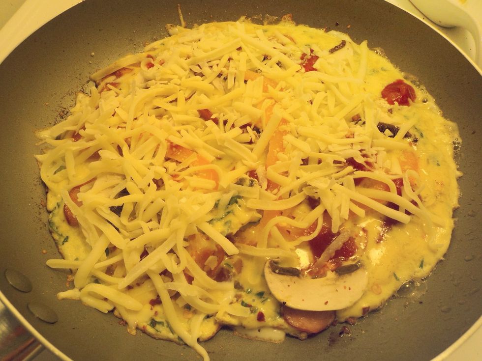 Sprinkle on the chili or spaghetti sauce and the grated mozzarella cheese. Cook the omelette until the bottom is a nice golden brown. Remove from heat before it cooks any more.