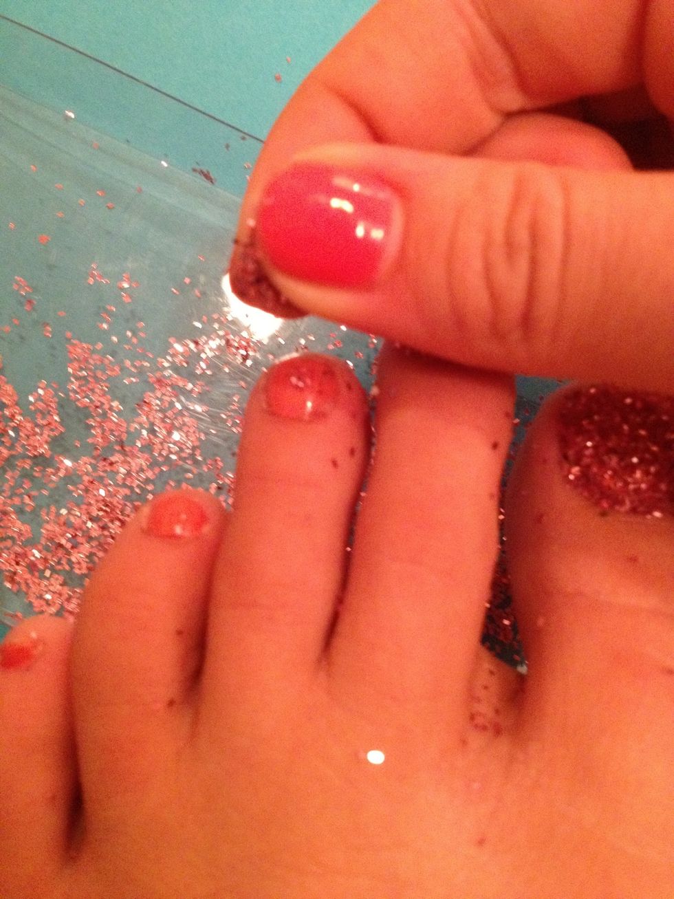 SPRINKLE on the glitter. be sure to have a paper or something underneath the area your using for easy cleanup.