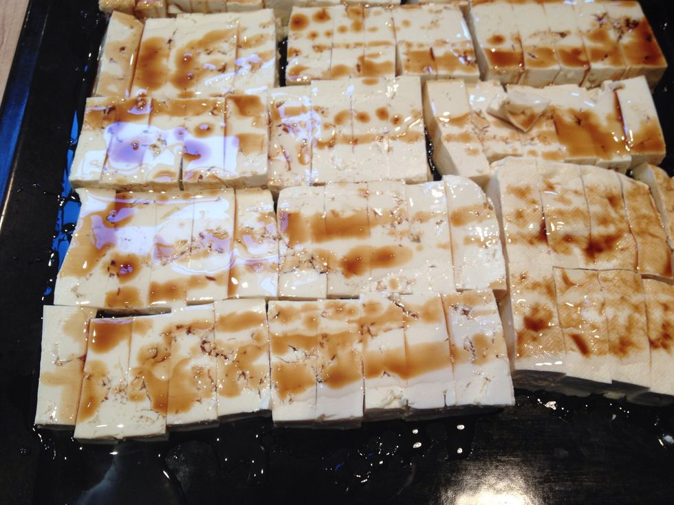 Sprinkle some tamari on the tofu. Again, go easy on it. We used to coat both sides but it seems that one side is sufficient as the oil and tamari coat the tofu when it gets flipped.