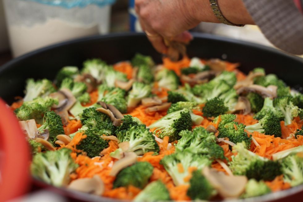Sprinkle the carrots and layer them with broccoli pieces. Throw your mushrooms around the baking tray. If someone in your family doesn't like mushrooms, put only half side.