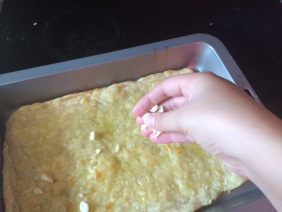 Sprinkle the garlic over the pizza base.