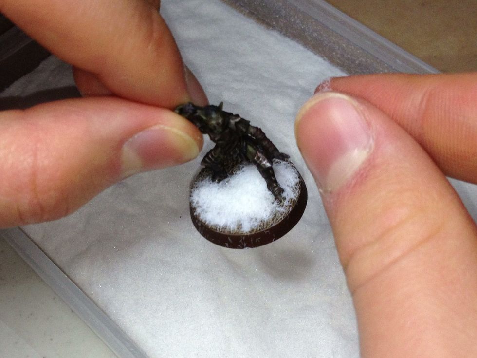 Sprinkle whatever you're using onto the patches of glue. This is referred to as "flocking the base". Make sure it's a heavy sprinkling.