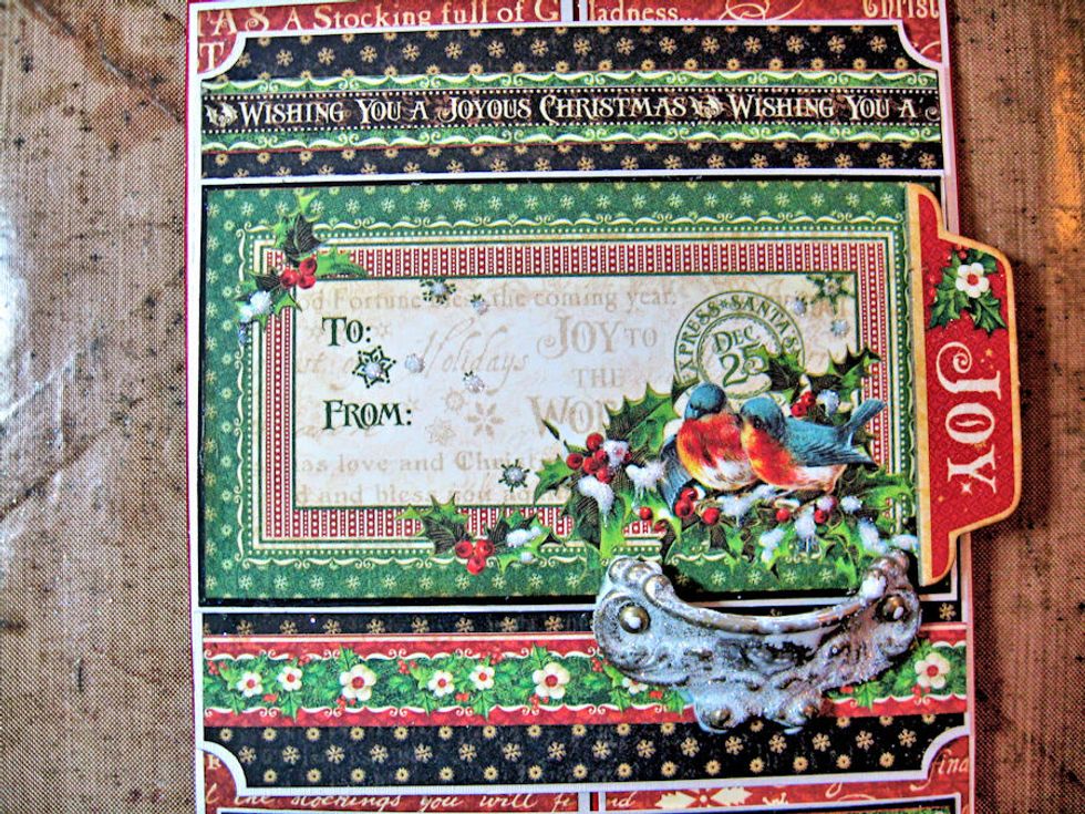 Sprinkle with glitter and tap off. Dry brush white acrylic paint onto Door Pull. Sprinkle with glitter. Attach to the card front, right below the bird image.