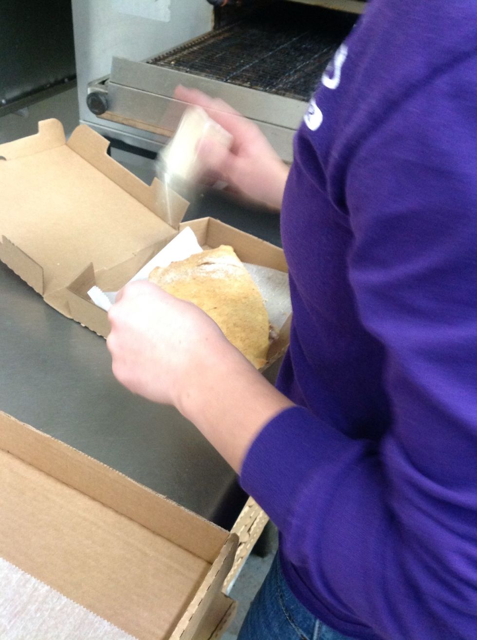 Sprinkling Parmesan cheese over the top of the calzone