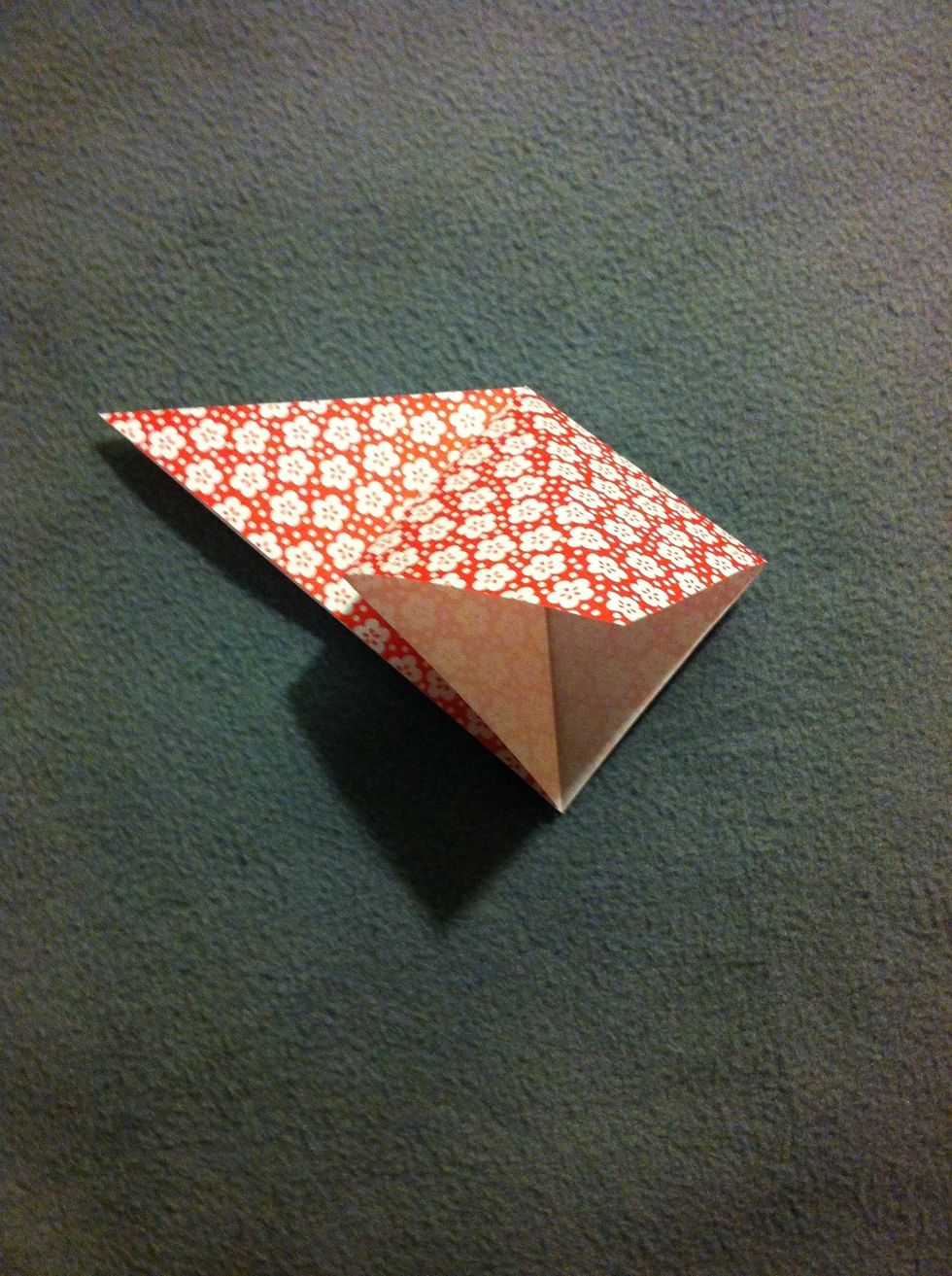 Squash fold a flap by putting your finger into the corner (actually the middle of the whole piece of paper) and pressing flat the flap. Comment if you have problems with my not-so-good explanation