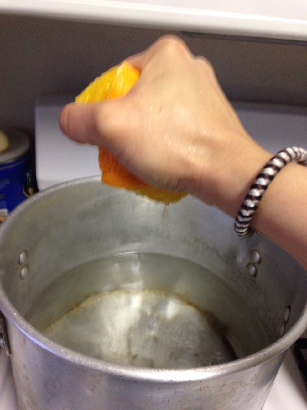 Squeeze orange juice in the water then place orange peels in water