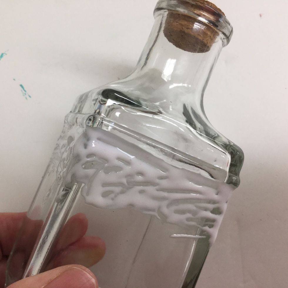 Squeeze tacky glue in an even band around the bottle - about 1/2" deep. Our bottle had a little ridge at the base of the neck. It was a good starting point!