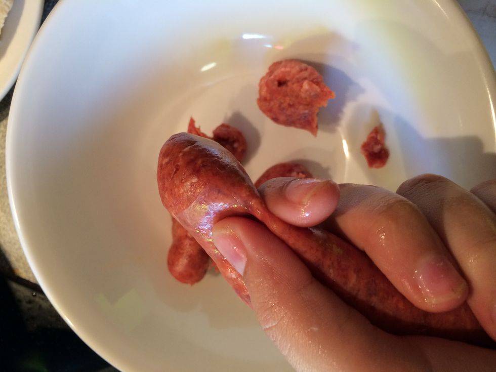 Squeeze the sausages and put the meat into a bowl.