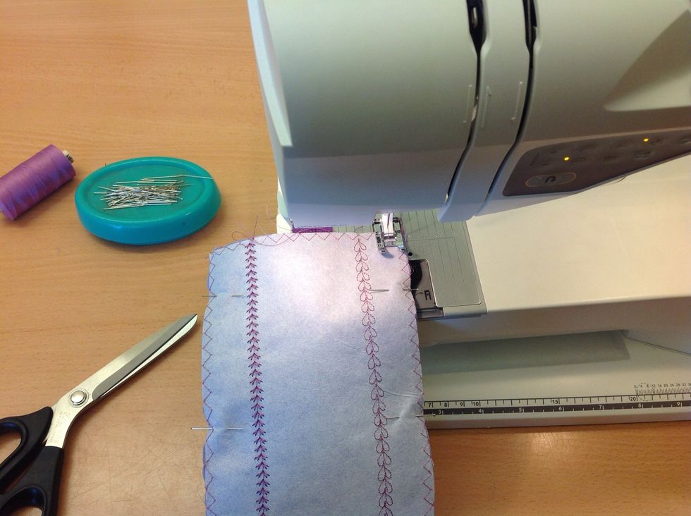 St\u00e4ll in raks\u00f6m. Sy runt hela pennfacket, 1cm fr\u00e5n kanten. Tygkanten ska ligga mot 10 p\u00e5 stygnpl\u00e5ten bredvid pressarfoten. Sy f\u00f6rsiktigt \u00f6ver dragkedjan.