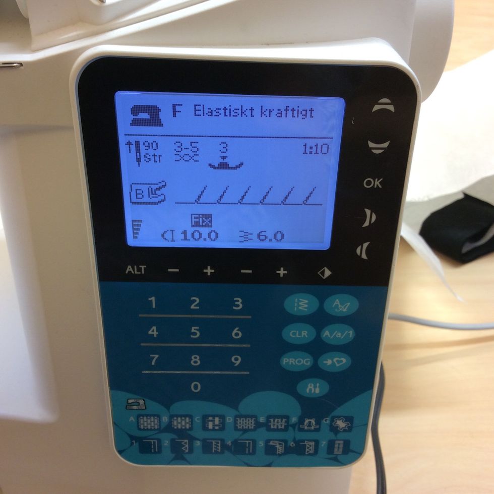 St\u00e4ll in symaskinen p\u00e5 elastiskt kraftigt tyg (knapp F) och p\u00e5 s\u00f6m nummer 10. ( denna s\u00f6m anv\u00e4nder du f\u00f6r trik\u00e5/stretchiga tyger.