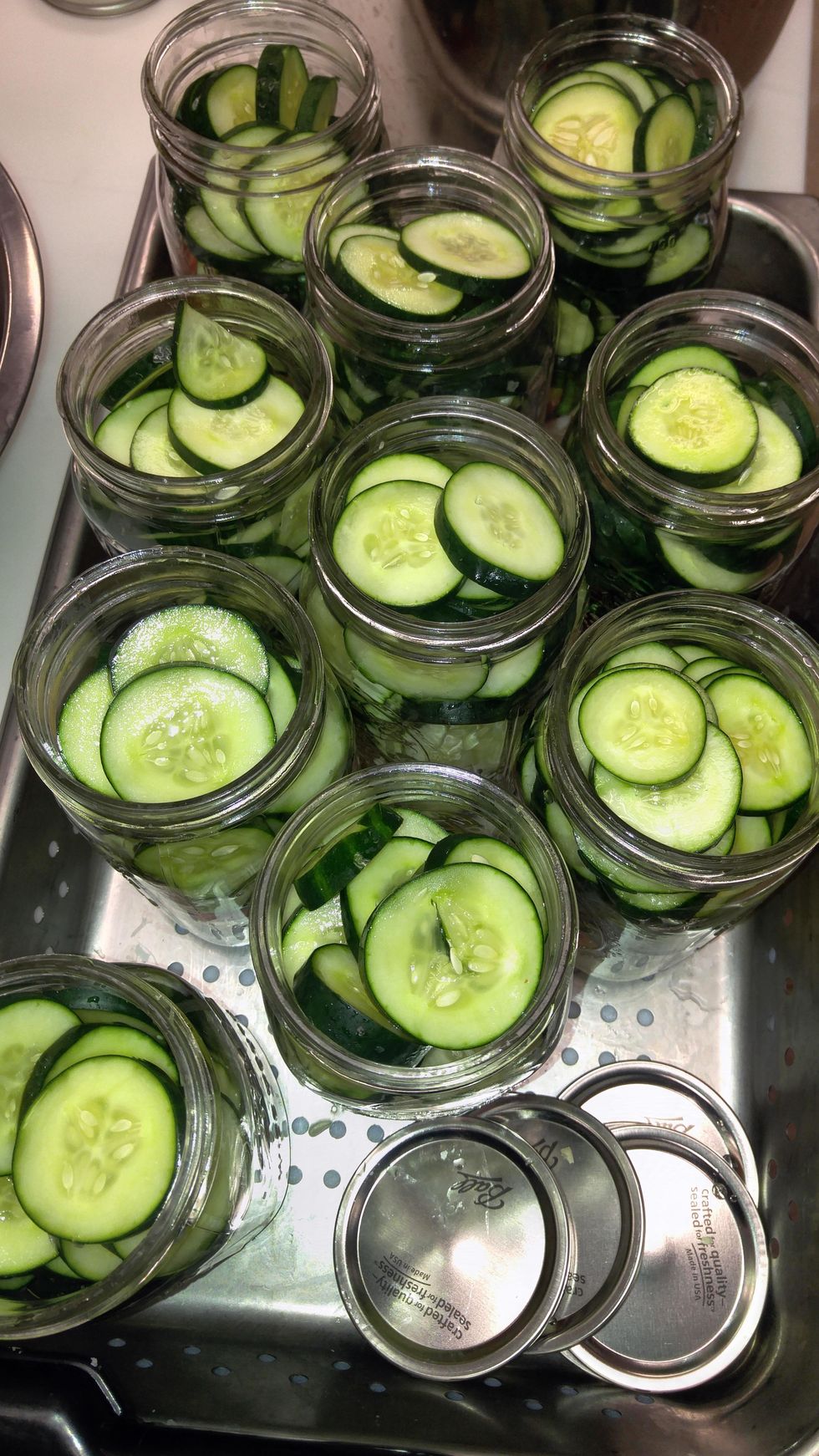 stack sliced cucumbers on top of the peppers and onions.
