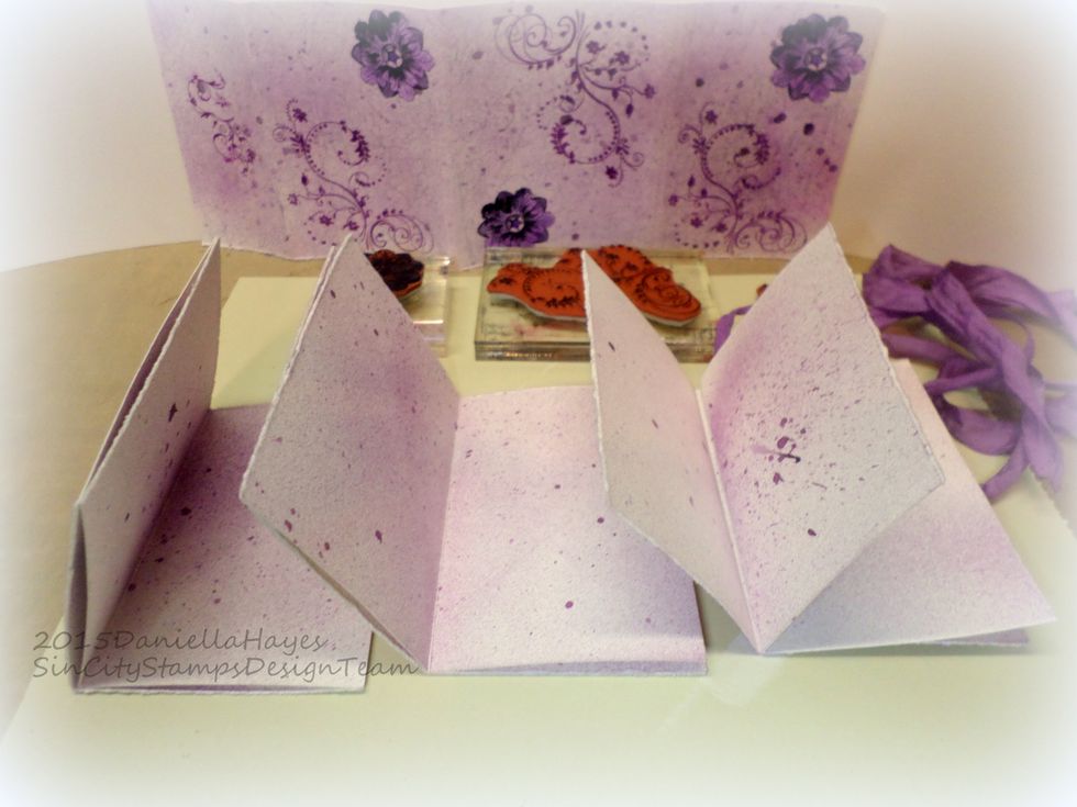 Stamp a small swirl or a flower on each page of the book. You should have 3 sets of 2 pages that are scored in the center. These are called "Signatures". You should have 3 "Signatures".