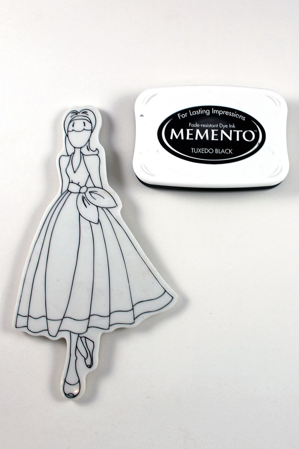 Stamp image on watercolor tag. Color skin, shoes & hair with watercolor pencils and watercolor brush pen. Adhere dress shape from step 2. Use Stickles to add sparkle to shoes and headband.