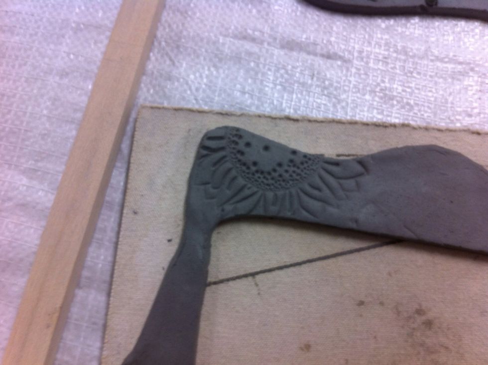Stamp the image. Push firmly! Hold the clay in place as you peel off the stamp.