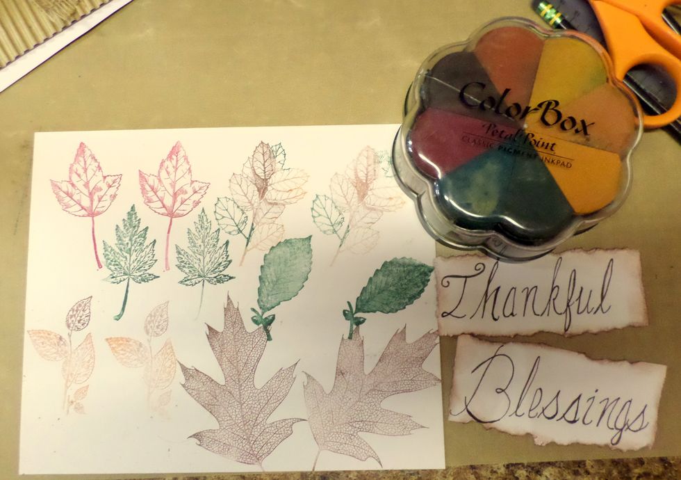 Stamp the same leaves in the same colors on cardstock. Tear 2 pieces of cardstock, approx 4" long by 2"high, write "Thankful" and "Blessings" on them and ink edges. Cut out the leaves.